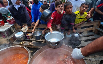 Palestinians wait for food at a distribution point in Nuseirat, central Gaza Strip, June 2, 2025. (Eyad BABA / AFP)