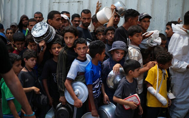 Palestinian children wait for food at a distribution point in Nuseirat, central Gaza Strip, June 2, 2025 (Eyad BABA / AFP)