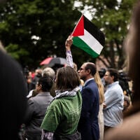 FILE: A protestor waves a Palestinian flag during a community gathering at the site of an antisemitic firebombing attack against people who were demonstrating on behalf of the hostages being held by Hamas in Gaza, in Boulder, Colorado, on June 4, 2025. (Photo by Chet Strange / AFP)
