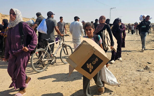 Palestinians walk along a road to receive humanitarian aid packages from the US-backed Gaza Humanitarian Foundation in Rafah, in the southern Gaza Strip, on June 5, 2025. (AFP)