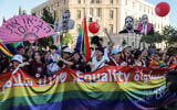 Participants hoist cut-outs of anti-LGBTQ Israeli politicians and a giant pride flag with the words 'equality' and 'peace' in Hebrew, English and Arabic as they march through Jerusalem's city center during the capital's annual Pride Parade, on June 5, 2025. (AHMAD GHARABLI / AFP)