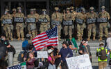 Demonstrators holding signs and flags face California National Guard members standing guard outside the Federal Building as they protest federal immigration operations in Los Angeles, on June 9, 2025. (Apu GOMES / AFP)