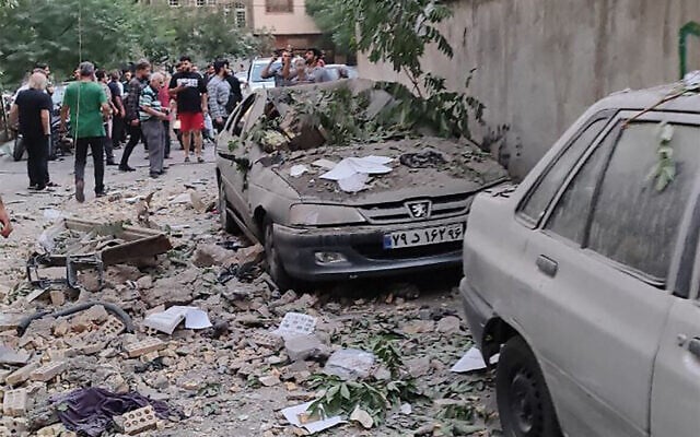 This handout photo released by Iran's Revolutionary Guard Corps (IRGC) official Sepah News Telegram channel on June 13, 2025 shows people next to the rubble outside a building reportedly targeted by an Israeli strike on the Iranian capital Tehran (SEPAH NEWS / AFP) This handout photo released by Iran's Revolutionary Guard Corps (IRGC) official Sepah News Telegram channel on June 13, 2025 shows people next to the rubble outside a building reportedly targeted by an Israeli strike on the Iranian capital Tehran (SEPAH NEWS / AFP)
