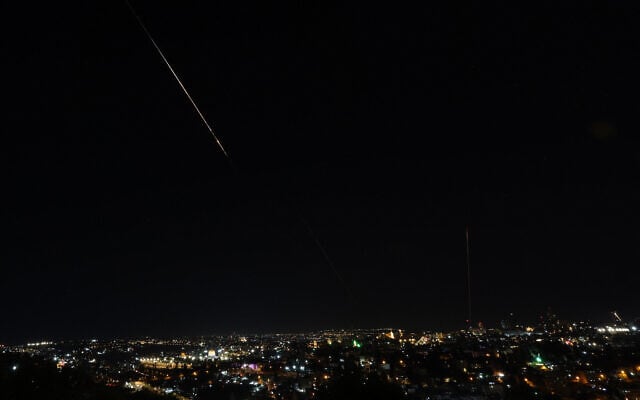 Debris of a missile fired from Iran toward Israel leaves a trail in the night sky over Jerusalem after being intercepted on June 13, 2025. (AHMAD GHARABLI / AFP) Debris of a missile fired from Iran toward Israel leaves a trail in the night sky over Jerusalem after being intercepted on June 13, 2025. (AHMAD GHARABLI / AFP)