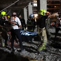 First responders evacuate a victim from a building hit by a missile fired from Iran, in Ramat Gan near Tel Aviv on June 13, 2025.  (Jack GUEZ / AFP)