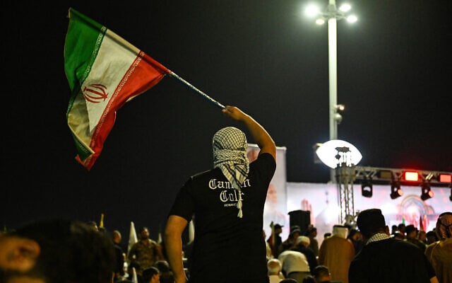 A demonstrator waves an Iranian flag, during a protest against Israel's attack on Iran, in Basra on June 13, 2025. (Hussein FALEH / AFP) A demonstrator waves an Iranian flag, during a protest against Israel's attack on Iran, in Basra on June 13, 2025. (Hussein FALEH / AFP)