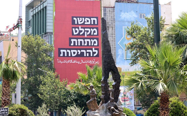 An anti-Israel poster, which reads in Persian "look for shelters among the debris," hangs on the side of building in Tehran on June 14, 2025. (Atta KENARE / AFP) An anti-Israel poster, which reads in Persian "look for shelters among the debris," hangs on the side of building in Tehran on June 14, 2025. (Atta KENARE / AFP)