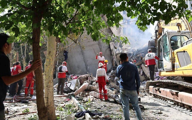 Iranian Red Crescent volunteers gathered in front of a building destroyed in an Israeli strike in Tehran, June 14, 2025. (Iranian Red Crescent / AFP) Iranian Red Crescent volunteers gathered in front of a building destroyed in an Israeli strike in Tehran, June 14, 2025. (Iranian Red Crescent / AFP)
