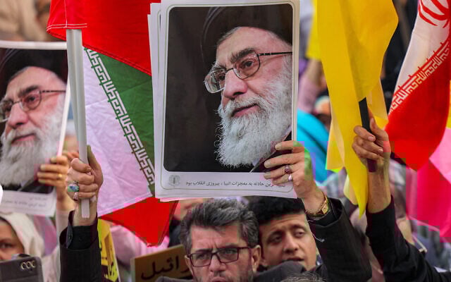 A demonstrator holds a picture of Iran's Supreme Leader Ayatollah Ali Khamenei while gathering with others during a rally in solidarity with the government against Israel's attacks on Iran at Enghelab (Revolution) Square in Tehran on June 14, 2025. (Photo by ATTA KENARE / AFP)