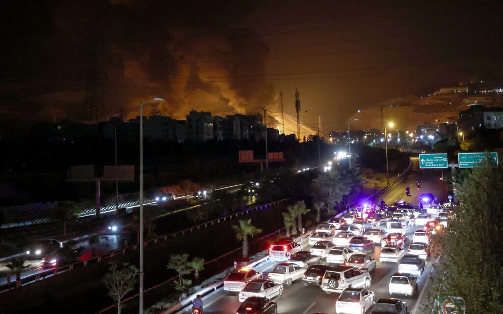Vehicles jam a highway as a fire blazes nearby in the oil depots of Shahran, northwest of Tehran, Iran, on June 15, 2025. (Atta Kenare/AFP)