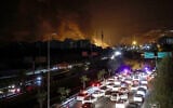 Vehicles jam a highway as a fire blazes nearby in the oil depots of Shahran, northwest of Tehran, Iran, on June 15, 2025. (Atta Kenare/AFP)