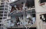 Responders work in a damaged building following a strike by an Iranian missile in the city of Bat Yam, south of Tel Aviv, early on June 15, 2025.  (Jack Guez / AFP)