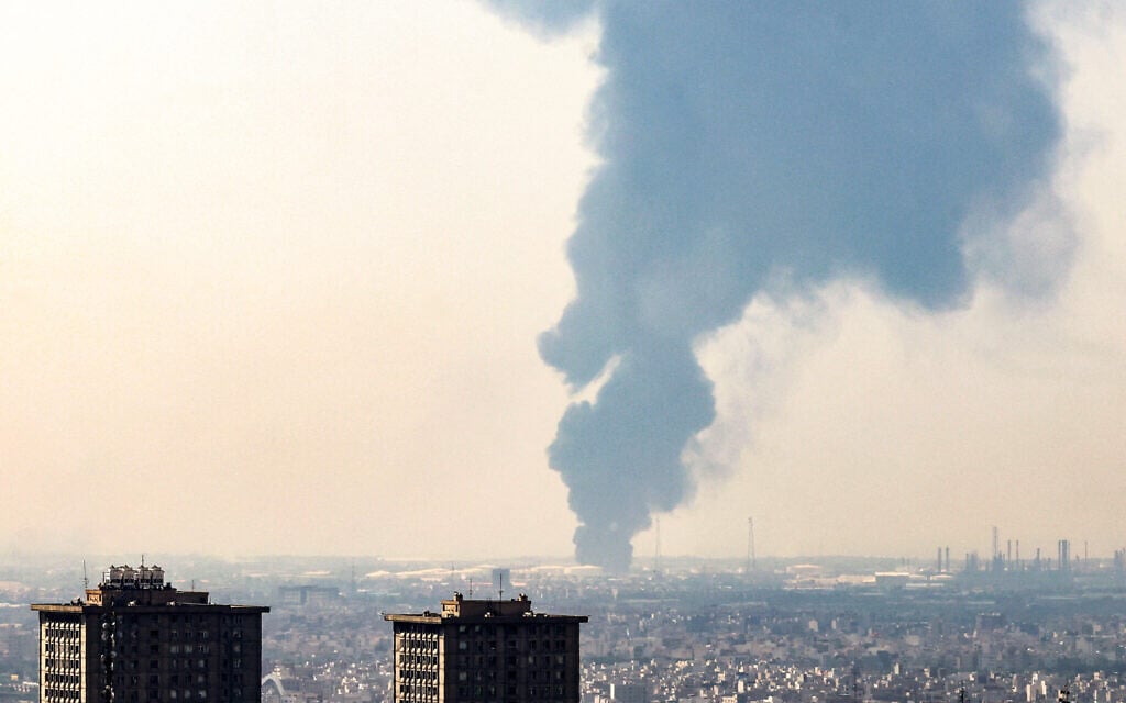 A plume of heavy smoke rises over an oil refinery in southern of Tehran, after it was hit in an overnight Israeli strike, on June 15, 2025. (Photo by Atta KENARE / AFP)