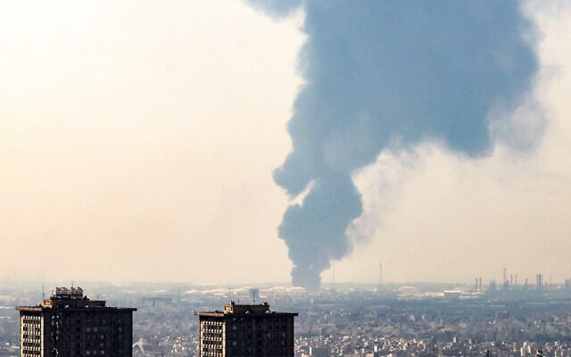 A plume of heavy smoke rises over an oil refinery in southern of Tehran, after it was hit in an overnight Israeli strike, on June 15, 2025. (Photo by Atta KENARE / AFP)