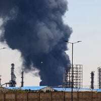 A plume of heavy smoke and fire rise over an oil refinery in southern Tehran, after it was hit in an overnight Israeli strike, on June 15, 2025. (Photo by ATTA KENARE / AFP)
