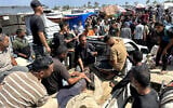 Palestinians evacuate a wounded man amid lines for receiving humanitrian aid in the southern Gaza city of Rafah on June 15, 2025. (AFP)