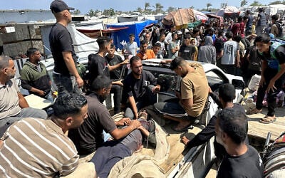 Palestinians evacuate a wounded man amid lines for receiving humanitrian aid in the southern Gaza city of Rafah on June 15, 2025. (AFP)