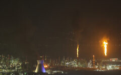 Flames and smoke billow after an Iranian missile struck an oil refinery in Haifa, northern Israel, early June 16, 2025. (Ahmad GHARABLI / AFP)