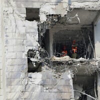 Responders inspect a damaged building following a strike by an Iranian missile in Petah Tikva on June 16, 2025. (Jack GUEZ / AFP)