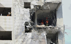 Responders inspect a damaged building following a strike by an Iranian missile in Petah Tikva on June 16, 2025. (Jack GUEZ / AFP)