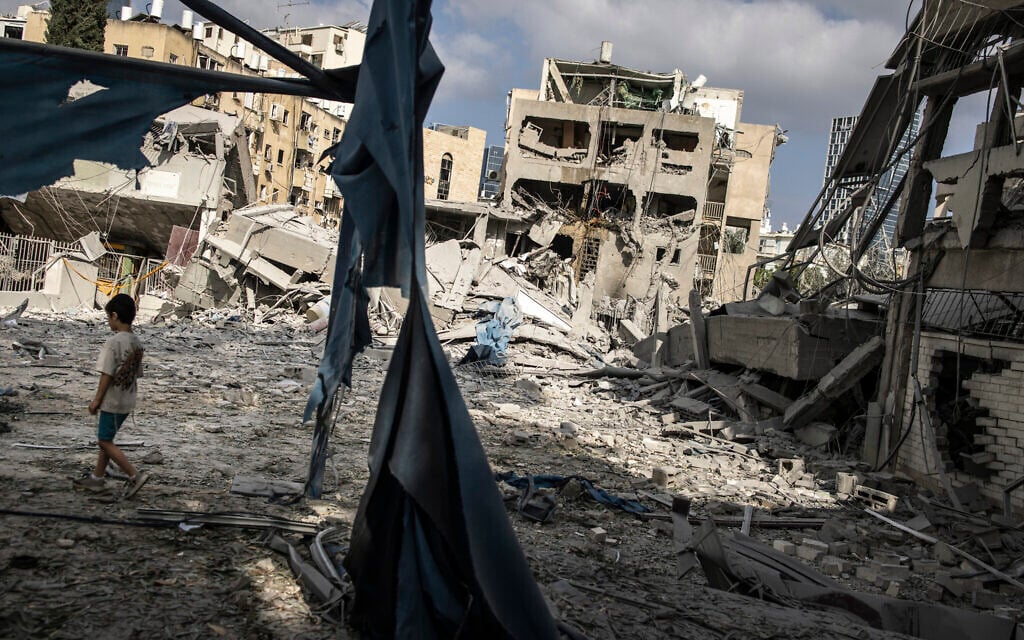 A young boy walks through the debris at the site of an Iranian missile strike in Bnei Brak on June 16, 2025. (JOHN WESSELS / AFP)
