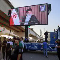 Supporters of Iraqi pro-Iran groups wheel a screen displaying Iran's supreme leader, Ayatollah Ali Khamenei, during a protest in Baghdad near the green zone, the ultra-secured neighborhood hosting the US embassy, on June 16, 2025, (AHMAD AL-RUBAYE / AFP)