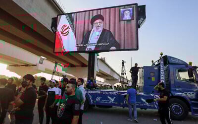 Supporters of Iraqi pro-Iran groups wheel a screen displaying Iran's supreme leader, Ayatollah Ali Khamenei, during a protest in Baghdad near the green zone, the ultra-secured neighborhood hosting the US embassy, on June 16, 2025, (AHMAD AL-RUBAYE / AFP)