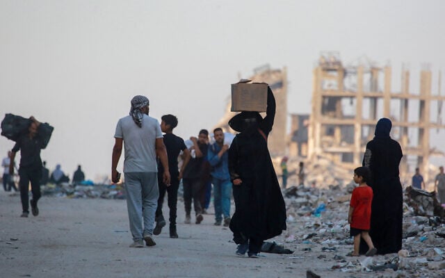 A Palestinian woman carries a humanitarian aid package west of Jabalia in the northern Gaza Strip, on June 16, 2025. (Bashar TALEB / AFP) A Palestinian woman carries a humanitarian aid package west of Jabalia in the northern Gaza Strip, on June 16, 2025. (Bashar TALEB / AFP)