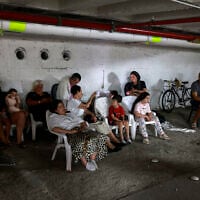 People take shelter in a parking lot in Tel Aviv amid a fresh barrage of Iranian rockets on June 17, 2025. (Menahem Kahana / AFP)