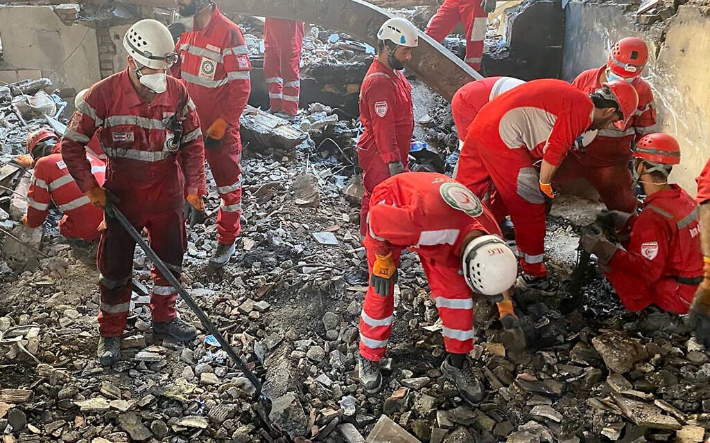 This handout picture released by the Iranian Red Crescent on June 17, 2025, shows members of rescue teams searching the debris inside a building in Tehran targeted by Israeli strikes. (Iranian Red Crescent / AFP)