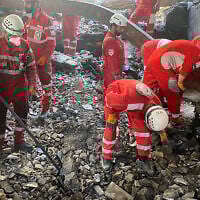 This handout picture released by the Iranian Red Crescent on June 17, 2025, shows members of rescue teams searching the debris inside a building in Tehran targeted by Israeli strikes. (Iranian Red Crescent / AFP)