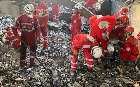 This handout picture released by the Iranian Red Crescent on June 17, 2025, shows members of rescue teams searching the debris inside a building in Tehran targeted by Israeli strikes. (Iranian Red Crescent / AFP)