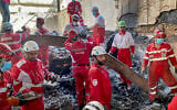 This handout picture released by the Iranian Red Crescent on June 17, 2025, shows members of rescue teams searching the debris inside a building in Tehran targeted by Israeli strikes (Iranian Red Crescent / AFP)