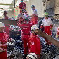 This handout picture released by the Iranian Red Crescent on June 17, 2025, shows members of rescue teams searching the debris inside a building in Tehran targeted by Israeli strikes (Iranian Red Crescent / AFP)