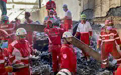This handout picture released by the Iranian Red Crescent on June 17, 2025, shows members of rescue teams searching the debris inside a building in Tehran targeted by Israeli strikes (Iranian Red Crescent / AFP)