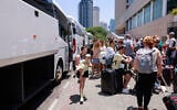People arrive with their luggage before the departure of a bus slated to evacuate foreign passport holders, mainly Europeans, out of Israel, at a meeting point in Tel Aviv on June 17, 2025. The operation, coordinated by the Polish embassy, aims to evacuate several hundred people who will board buses headed to Sinai in Egypt, and from there continue to Warsaw, Poland. (Photo by Menahem Kahana / AFP)