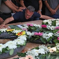 Raja Khatib mourns over a casket during the funeral of four members of his family killed in an Iranian missile attack which destroyed their home in the northern Arab-Israeli city of Tamra, June 17, 2025. (Ahmad Gharabli/AFP)