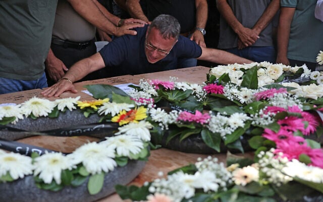 Raja Khatib mourns over a casket during the funeral of four members of his family killed in an Iranian missile attack which destroyed their home in the northern Arab-Israeli city of Tamra, June 17, 2025. (Ahmad Gharabli/AFP)