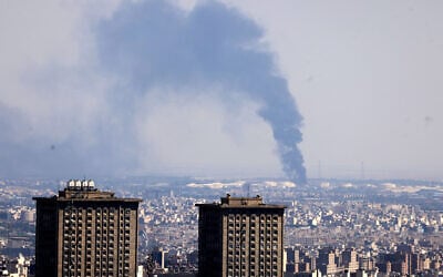 Smoke billows in the distance from an oil refinery following an Israeli strike on the Iranian capital Tehran on June 17, 2025. (ATTA KENARE / AFP)