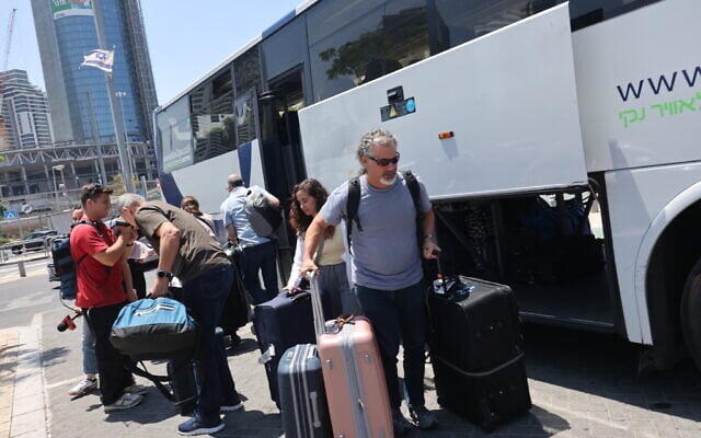 Israelis disembark a bus in Tel Aviv after they were flown back to Israel in a special flight, on June 18, 2025. (GIL COHEN-MAGEN / AFP) Israelis disembark a bus in Tel Aviv after they were flown back to Israel in a special flight, on June 18, 2025. (GIL COHEN-MAGEN / AFP)