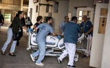 Doctors wheel a patient to safety after a building at Soroka Hospital was struck by an Iranian missile in Beersheba in southern Israel on June 19, 2025.  (Photo by JOHN WESSELS / AFP)
