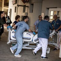 Doctors wheel a patient to safety after a building at Soroka Hospital was struck by an Iranian missile in Beersheba in southern Israel on June 19, 2025. (JOHN WESSELS / AFP)