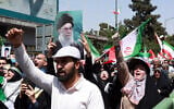 An Iranian carries a portrait of Iran's Supreme Leader Ayatollah Ali Khamenei as others wave the national flag and chant slogans during an anti-Israeli rally in Tehran on June 20, 2025. (Photo by AFP)