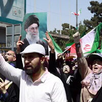 An Iranian carries a portrait of Iran's Supreme Leader Ayatollah Ali Khamenei as others wave the national flag and chant slogans during an anti-Israeli rally in Tehran on June 20, 2025. (Photo by AFP)