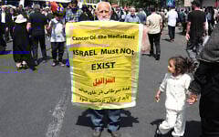 An Iranian carries a placard calling for the destruction of Israel during a rally in Tehran on June 20, 2025.  (Photo by AFP)