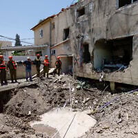 Israeli soldiers and first responders check the damage caused to a building from an Iranian strike in Beit She'an on June 21, 2025. (Jalaa MAREY / AFP)