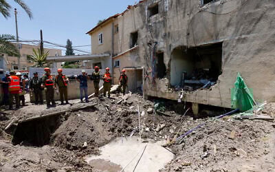 Israeli soldiers and first responders check the damage caused to a building from an Iranian strike in Beit She'an on June 21, 2025. (Jalaa MAREY / AFP)