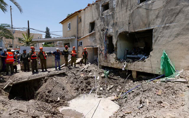 Israeli soldiers and first responders check the damage caused to a building from an Iranian strike in Beit She'an on June 21, 2025. (Jalaa MAREY / AFP)