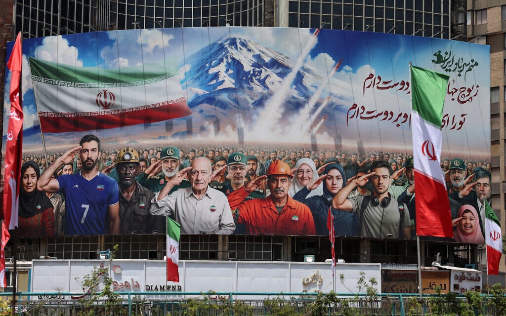 بنری حاوی نقاشی که دستههای مختلف جامعه ایرانی را نشان میدهد، در ۲۲ ژوئن ۲۰۲۵ در نمای ساختمانی در میدان ولیعصر تهران نصب شده است، با پیامی به فارسی که میخواند: 'همه ما سربازان ایرانیم.'