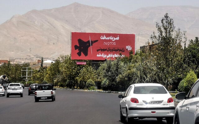 Commuters drive past an anti-Israel billboard in Tehran, on June 22, 2025. (Photo by ATTA KENARE / AFP)